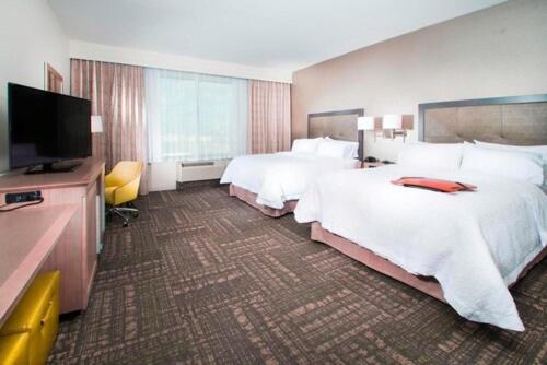 a hotel room with two beds and a flat screen tv at Hampton Inn & Suites La Porte, TX in La Porte