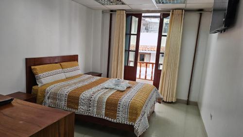 ein Schlafzimmer mit einem Bett und einem Fenster in der Unterkunft Hostal Ticlio in Cajamarca