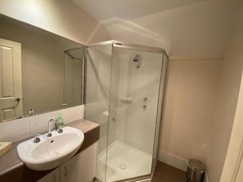 a bathroom with a glass shower and a sink at SixtySix at Cape View in Broadwater