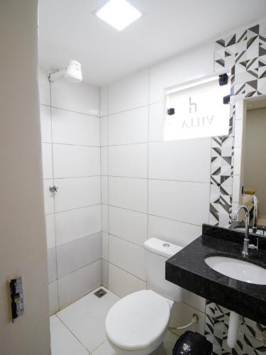 a bathroom with a toilet and a sink at Villa Hospedagem in Palmas