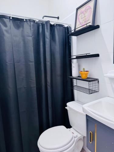 a bathroom with a black shower curtain and a toilet at Loft Mango in Tuxtla Gutiérrez
