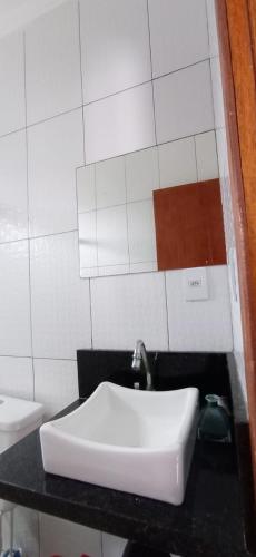 a bathroom with a white sink on a black counter at Bozena Beach Stay in Itacaré