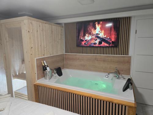 a bath tub with a fire in a room at Jacuzzi & Sauna Edy room - city center in Zagreb