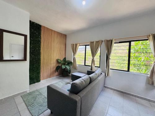 a living room with a couch and two windows at Loft Mango in Tuxtla Gutiérrez