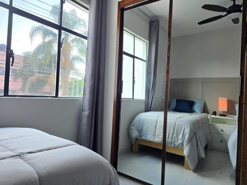 a bedroom with a mirror and a bed and a window at Casa amplia para grupos Remodelada y centrica in Guadalajara