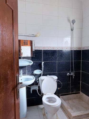 a bathroom with a toilet and a sink at Happy House in Al Ain