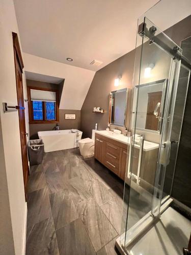 a bathroom with a tub and two sinks and a shower at Manoir Signature in Mont-Tremblant
