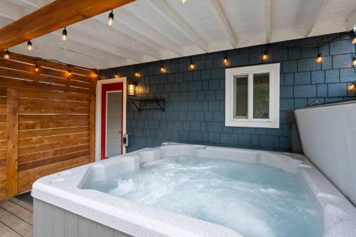 a jacuzzi tub in a room with blue tiles at Cozy Coastal Cabin in Rockaway Beach
