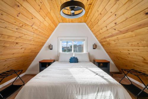a bed in a room with a wooden ceiling at Cozy Coastal Cabin in Rockaway Beach