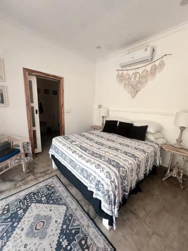 a bedroom with a bed with a blue and white comforter at Bliss Villa Central Kuta in Kuta Lombok