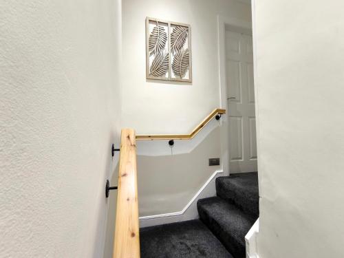 a staircase in a house with a picture on the wall at Carrick's Cosy Haven in Carrickfergus