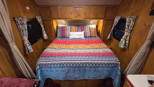 a small bed in the back of a small room at Edith the Happy Camper in High Springs