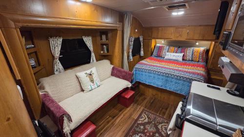 a small room with a bed and a couch at Edith the Happy Camper in High Springs