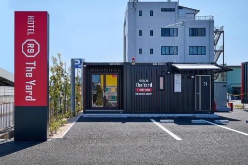 a parking lot with a black building in the background at HOTEL R9 The Yard Nagahamainter in Nagahama