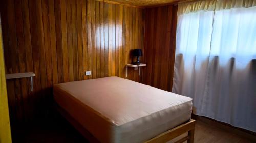 a small bedroom with a bed and a window at Böttger Haus in Oxapampa