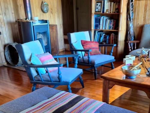 a living room with blue chairs and a table at Hostal Boutique El Vergel Azul in Castro
