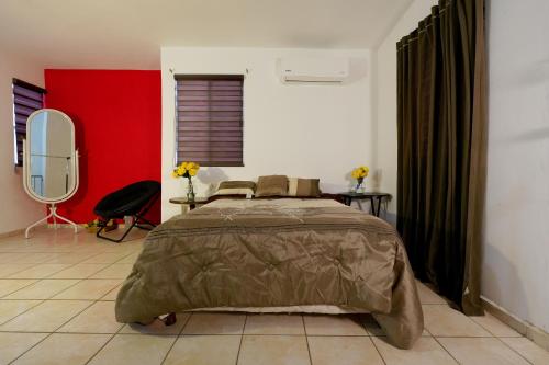 a bedroom with a large bed and a red wall at Ribera Dorada in Monterrey