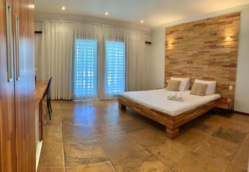 a bedroom with a bed and two windows at Pousada Refugio Jardim de Canoa in Canoa Quebrada