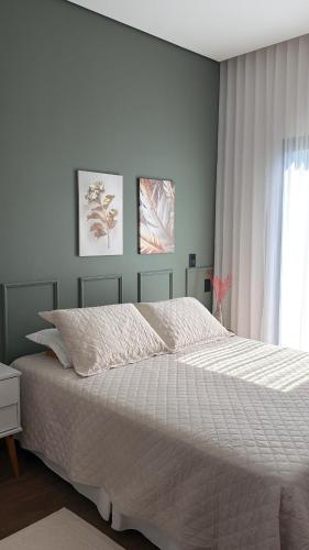 a bedroom with a large white bed with a window at Cantinho Solis in Itupeva