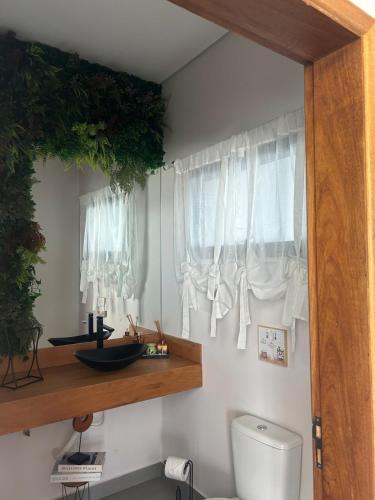 a bathroom with a toilet and a window at Cantinho Solis in Itupeva