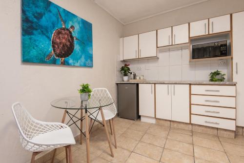 a kitchen with a table and a turtle painting on the wall at The Beach Palace Ramsgate in Margate