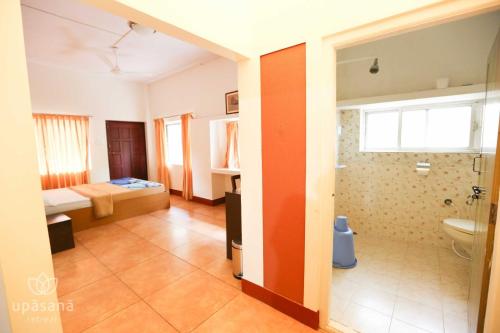 a large room with a bedroom and a bathroom at Upasana Retreat in Kalasa