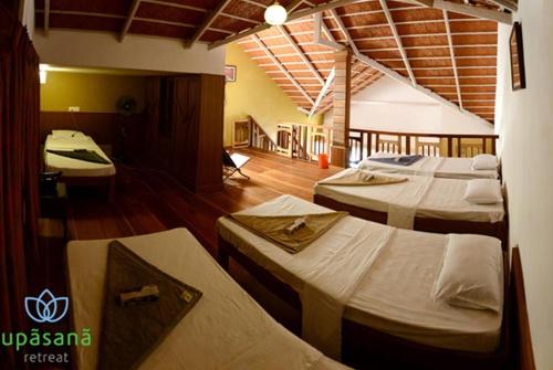 a room with three beds in it with a room with at Upasana Retreat in Kalasa