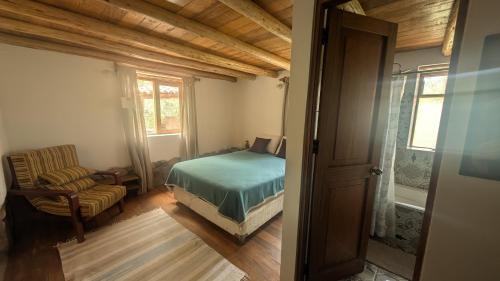 a bedroom with a bed and a chair and a window at Casa Nuestra - Room with Private Bathroom in Shared House in Urubamba