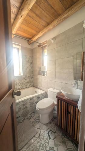a bathroom with a toilet and a tub and a sink at Casa Nuestra - Room with Private Bathroom in Shared House in Urubamba