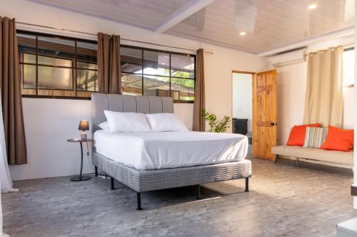 a bedroom with a large bed and a couch at Nosara Hotel Playa Garza in Garza