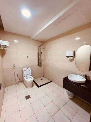 a bathroom with a toilet and a sink at كاسا للشقق المخدومة 2 in Dammam