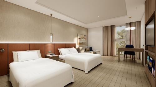 a hotel room with two beds and a desk at Charis Hotel in Incheon
