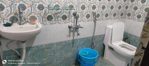 a bathroom with a sink and a toilet at Sakez Homestays HH in Hyderabad