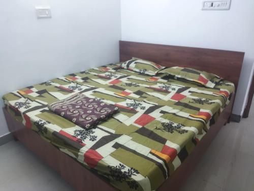 a bed with a quilt on top of it at WooLiv in Coimbatore
