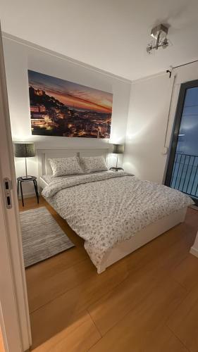 a bedroom with a bed and a painting on the wall at sony cottage in Lisbon