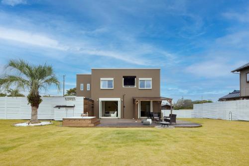 a house with a palm tree in a yard at The Garden Villa 九十九里ー遊び充実の海近リゾート別荘を最大15名で一棟貸切 in Shirako