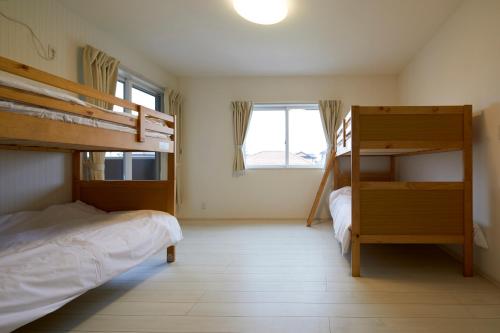 a bedroom with two bunk beds and a window at The Garden Villa 九十九里ー遊び充実の海近リゾート別荘を最大15名で一棟貸切 in Shirako