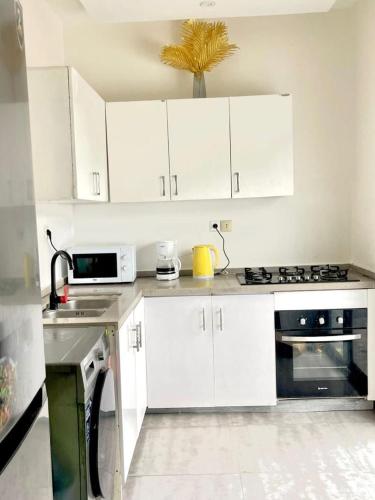 a kitchen with white cabinets and a stove top oven at Goat1 in Dakar