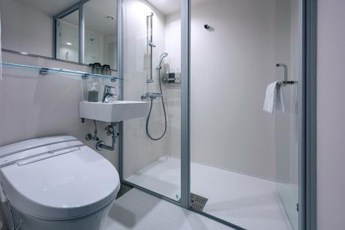 a bathroom with a shower and a toilet and a sink at THE KNOT FUKUOKA Tenjin in Fukuoka