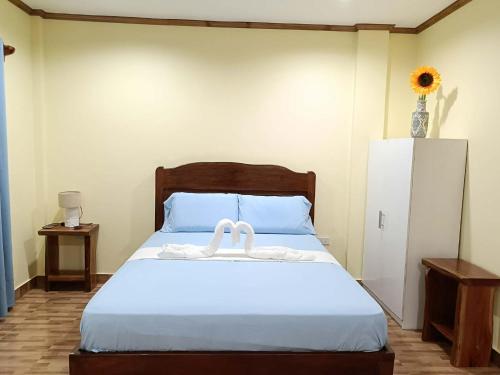 a bedroom with a bed with two white towels on it at Room 5 in Siquijor