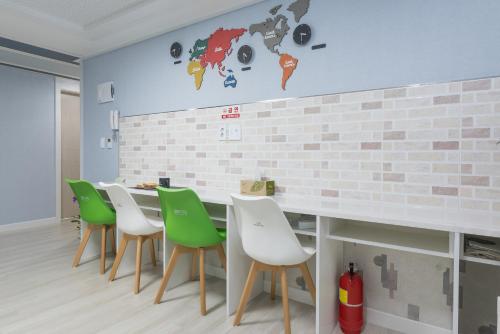 a dining room with a table and green chairs at DreamTrip Guesthouse in Incheon