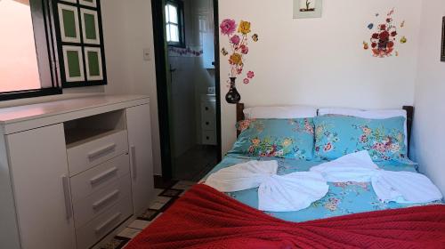 a small bedroom with a bed and a dresser at Chalé da Ana in Ouro Preto