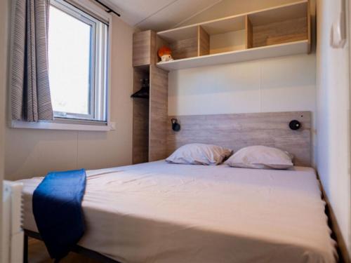 a bed with two pillows and a window in a room at Cottage avec clim - 4 pers. - API-1-52-2191 in Balaruc-les-Bains