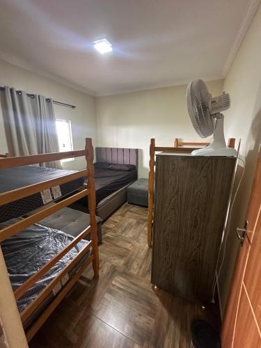 a room with two bunk beds and a fan at Sítio com piscina em bh mirante do Sol in Santa Luzia