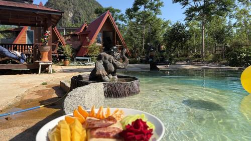 a plate of food on a table next to a fountain at Thanya campsite Thailand in Ban Thai Thai