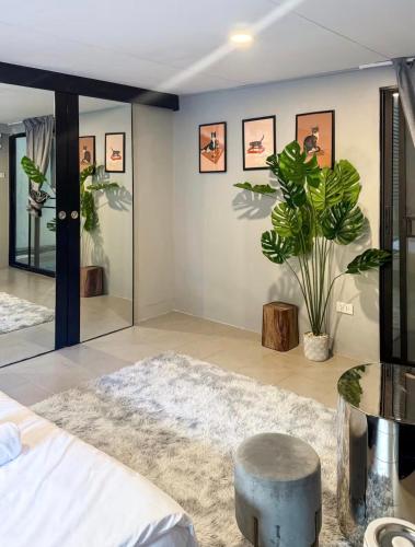 a bedroom with a bed and a table and a potted plant at Pridi cozy home with good location Type B in Bangkok