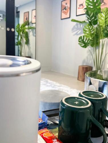two green coffee mugs sitting on a table at Pridi cozy home with good location Type B in Bangkok