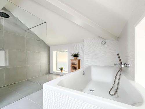 a white bathroom with a tub and a window at Wellness Escape with Private Sauna in Sibculo