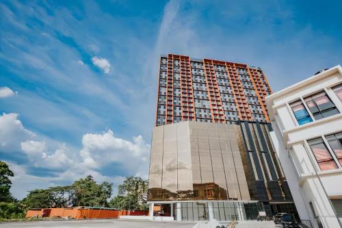 a tall building next to a white building at Piccadilly Service Residence Greentown Ipoh in Ipoh