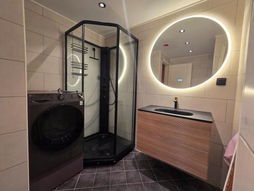 a bathroom with a shower and a sink and a mirror at Aurora Central Premium Apartment II, Bodø in Bodø